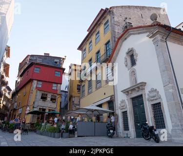 Restaurants inmitten von mehrstöckigen Hotels im Ribeira aka Flussviertel von Porto mit einer kleinen Kirche auf der rechten Seite, Portugal Stockfoto