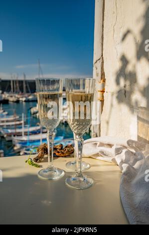 Drei Gläser französischer Champagner Sekt und Blick auf bunte Fischerboote im alten Hafen von Cassis, Provence, Frankreich, Sommerfest in PR Stockfoto