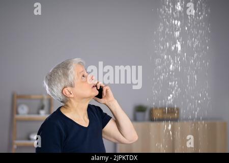 Besorgte Frau Ruft Klempner, Um Wasserleck Zu Beheben Stockfoto