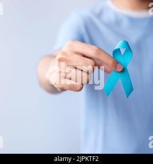 Blue November Prostata Krebs Bewusstsein Monat, Mann in blauem Hemd mit Hand halten Blue Ribbon für Menschen Leben und Krankheit zu unterstützen. Gesundheitswesen, Praktikant Stockfoto