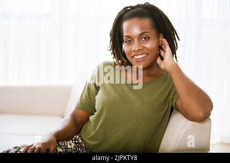 Porträt einer schönen afroamerikanischen Frau, die sich auf dem Sofa ausruht Stockfoto