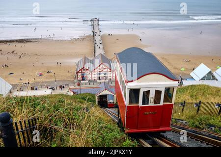Saltburn-by-the-Sea und seine wasserbetriebene Seilbahn Klippenbahn mit dem Pier und Strand im Hintergrund Stockfoto