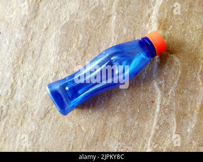 Blaue Plastick Wasserflasche isoliert auf Stein Hintergrund Stockfoto