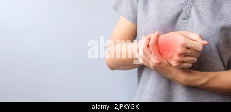 Frau, die ihr Handgelenk schmerzt, weil sie lange Zeit Smartphone oder Computer benutzt. De Quervain s Tenosynovitis, Kreuzungssymptom, Syndrom des Quervalltunnels Stockfoto