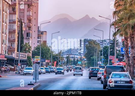 10. Juli 2022, Antalya, Türkei: Stadtboulevard mit Autostraße und Bergen im Hintergrund Stockfoto