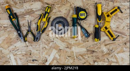 Das Wort ARBEIT aus Briefen von Bauwerkzeugen gesammelt. Hintergrund der OSB-Bauplatte. Für Text platzieren. Stockfoto