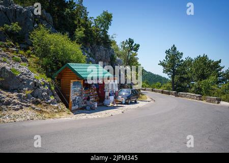 Kleines Touristengeschäft auf dem Berg auf der Aussichtsplattform Trojica in Montenegro in der Nähe von Kotor, das Souvenirs auf der Straße verkauft. Stockfoto