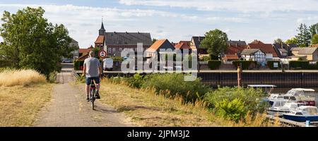 Schnackenburg, Deutschland - 3. August 2022: Mann auf dem Fahrrad fährt in Schnackenburg in niedersachsen an der ehemaligen innerdeutschen Grenze zwischen Ost- und Westdeutschland ein Stockfoto