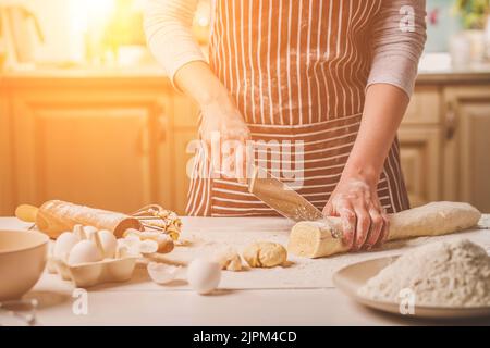 Nahaufnahme der beiden Frau Hände schneiden Messer Teig Stockfoto