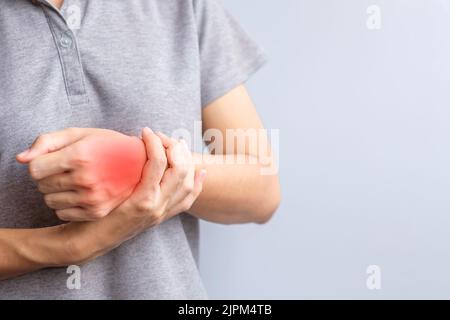 Frau, die ihr Handgelenk schmerzt, weil sie lange Zeit Smartphone oder Computer benutzt. De Quervain s Tenosynovitis, Kreuzungssymptom, Syndrom des Quervalltunnels Stockfoto