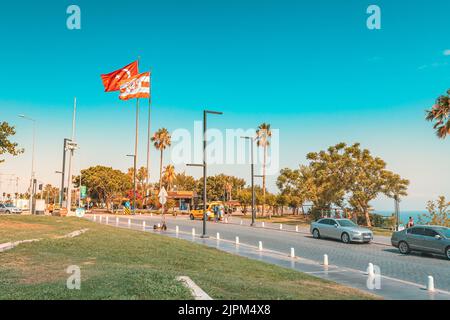 10. Juli 2022, Antalya, Türkei: Stadtstraße mit Autostraße und Fahrrad- und Fußgängerweg. Türkische Flagge auf einem Beobachtungspunkt Stockfoto