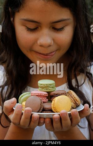 Leckere Makronen mit einem kleinen Mädchen. Stockfoto