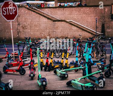 Viele bunte E-Scooter und Fahrräder zu mieten in den Straßen von Westdeutschland, Köln Stockfoto