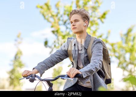 Student Junge mit Tasche und Kopfhörer Fahrrad fahren Stockfoto