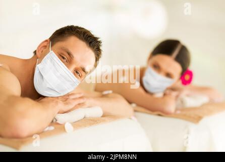 Paar in Masken im Spa Stockfoto