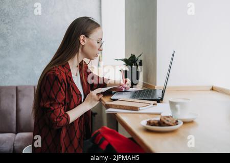 Produktiveres Arbeiten. Junge Studentin, Freiberuflerin, die mit einem Laptop arbeitet Stockfoto