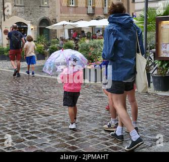 Die Sommerwoche ist von Wetterinstabilität geprägt. Gewitter und leuchtende Zaubersprüche blockieren den riesigen Touristenstrom nicht. Regenschirme offen gefärbt. Stockfoto