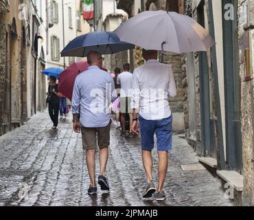 Die Sommerwoche ist von Wetterinstabilität geprägt. Gewitter und leuchtende Zaubersprüche blockieren den riesigen Touristenstrom nicht. Regenschirme offen gefärbt. Stockfoto