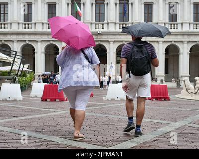 Die Sommerwoche ist von Wetterinstabilität geprägt. Gewitter und leuchtende Zaubersprüche blockieren den riesigen Touristenstrom nicht. Regenschirme offen gefärbt. Stockfoto