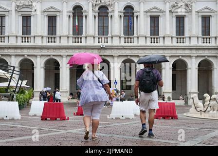 Die Sommerwoche ist von Wetterinstabilität geprägt. Gewitter und leuchtende Zaubersprüche blockieren den riesigen Touristenstrom nicht. Regenschirme offen gefärbt. Stockfoto