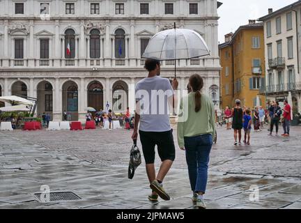 Die Sommerwoche ist von Wetterinstabilität geprägt. Gewitter und leuchtende Zaubersprüche blockieren den riesigen Touristenstrom nicht. Regenschirme offen gefärbt. Stockfoto