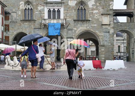 Die Sommerwoche ist von Wetterinstabilität geprägt. Gewitter und leuchtende Zaubersprüche blockieren den riesigen Touristenstrom nicht. Regenschirme offen gefärbt. Stockfoto