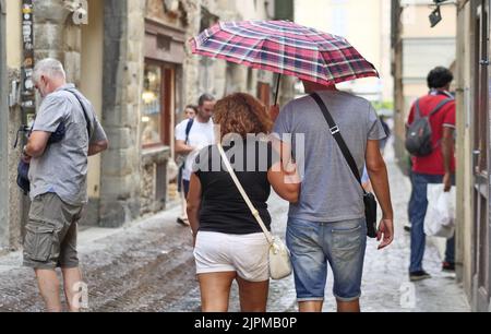 Die Sommerwoche ist von Wetterinstabilität geprägt. Gewitter und leuchtende Zaubersprüche blockieren den riesigen Touristenstrom nicht. Regenschirme offen gefärbt. Stockfoto