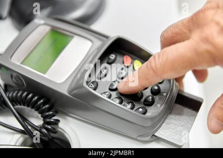 Nahaufnahme der Hand mit Kreditkarte im Kartenleser Stockfoto