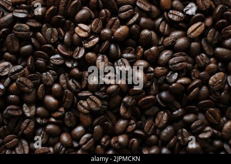 Kaffeebohnen Hintergrund. Frisch geröstete Kaffeebohnen Nahaufnahme. Stockfoto