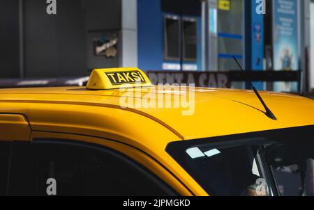Taxi-Schild auf dem Dach eines gelben Autos. Transport und Taxi-Service Stockfoto
