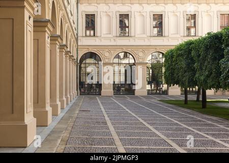 Innenhof des Czernin-Palastes (Černínský palác), in dem der Körper des Außenministers der Tschechoslowakei Jan Masaryk im Bezirk Hradčany in Prag, Tschechische Republik, gefunden wurde. Der Czernin-Palast diente als offizielle Residenz des Außenministers der Tschechoslowakei. Am 10. März 1948 wurde Jan Masaryk tot unter dem Fenster des Badezimmers seiner Wohnung aufgefunden. Wahrscheinlich beging er Selbstmord, indem er aus dem Fenster sprang oder wurde von den kommunistischen Behörden ermordet. Die schwarze Gedenktafel im Hintergrund markiert den Ort, an dem die Leiche gefunden wurde. Stockfoto