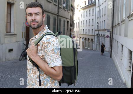 Hübscher Student mit Rucksack und Hemd im hawaiianischen Stil Stockfoto