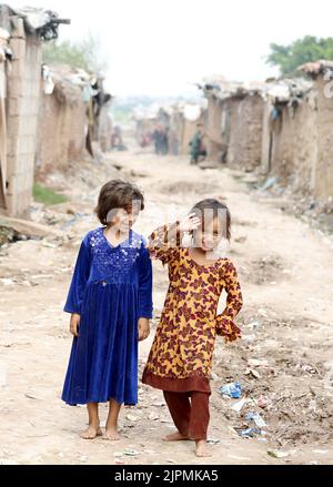 Islamabad, Pakistan. 18. August 2022. Afghanische Flüchtlingskinder spielen in einem Slum in Islamabad, der Hauptstadt Pakistans, am 18. August 2022. Der Welttag der humanitären Hilfe wurde am 19. August begangen. Quelle: Ahmad Kamal/Xinhua/Alamy Live News Stockfoto