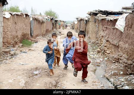 Islamabad, Pakistan. 18. August 2022. Afghanische Flüchtlingskinder spielen in einem Slum in Islamabad, der Hauptstadt Pakistans, am 18. August 2022. Der Welttag der humanitären Hilfe wurde am 19. August begangen. Quelle: Ahmad Kamal/Xinhua/Alamy Live News Stockfoto