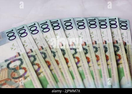 Ausgekleidete Banknoten von 100 weißrussischen Rubel auf grauem Hintergrund Stockfoto