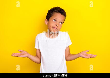 Foto von niedlichen stilvollen Jungen Arm Schulter heben weiß nicht Hausaufgaben oops sorry suchen leeren Raum auf gelbem Hintergrund isoliert Stockfoto