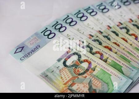 Ausgekleidete Banknoten von 100 weißrussischen Rubel auf grauem Hintergrund Stockfoto