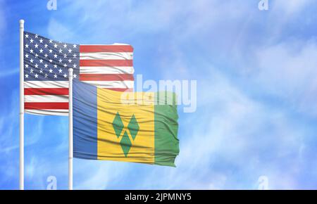 Schwenkende amerikanische Flagge und Flagge von St. Vincent und den Grenadinen. Stockfoto