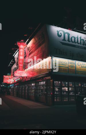 Eine schöne Aufnahme von Nathan's berühmtem Fast-Food-Restaurant am Abend Stockfoto