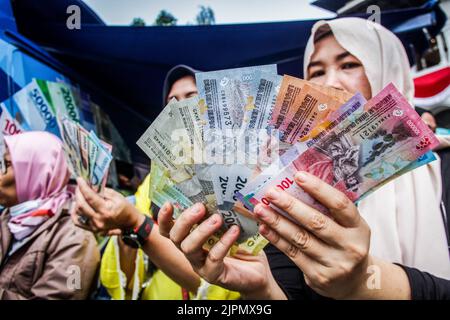 Bandung, Indonesien. 19. August 2022. In Bandung zeigen Frauen neue indonesische Banknoten. Die Regierung Indonesiens und die Bank Indonesia haben zum 77.. Jahrestag der Unabhängigkeit Indonesiens sieben neue Banknoten eingeführt. (Foto von Algi Febri Sugita/SOPA Images/Sipa USA) Quelle: SIPA USA/Alamy Live News Stockfoto