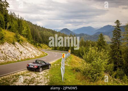 Sportwagen auf kurvenreicher Alpenstraße, Zellerrain-Pass, Zellerrain-Straße, bei Mariazell, Österreich, Mazda MX-5 NC, NC2, NCFL, Miata. Toller grüner Hintergr Stockfoto