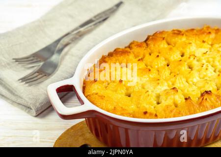 Shepherd's Pie oder Cottage Pie. Hackfleisch, Kartoffelpüree und Gemüseauflauf auf weißem Holzhintergrund aus nächster Nähe. Traditonal britisch, Vereinigte K Stockfoto