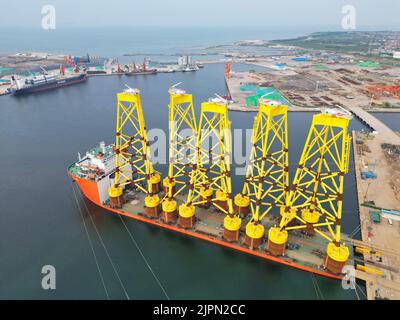 YANTAI, CHINA - 18. AUGUST 2022 - Eine Charge von Saugzylindermantel für Offshore-Windkraft verwendet wird an Bord geladen und bereit für den Export an einem Marine Stockfoto