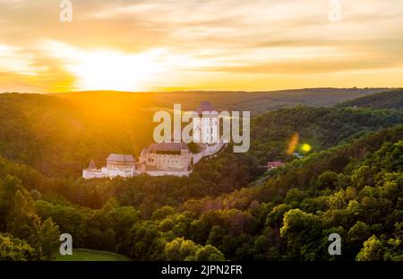 Luftaufnahme des wunderschönen Sonnenuntergangs über dem Schloss Karlstejn, Tschechische Republik. Drohne Aufnahme von alten Schloss mit in der Nähe von Wald. Burg im gotischen Stil war b Stockfoto