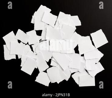 Weißes zerrissenes Papier auf schwarzem Hintergrund Stockfoto