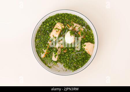 Banh Canh Cha Ca, Reisnudelsuppe mit Fischkuchen und Schnittlauch, vietnamesisches Essen isoliert auf weißem Hintergrund, Draufsicht Stockfoto