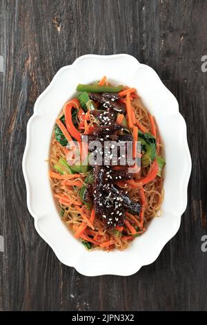 Japchae, CHAP Chae Korean Noodle Dish with Beef Bulgogi Topping, Draufsicht Stockfoto