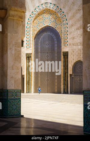 Ein Mädchen, das aus der wunderschönen Hassan II Moschee in Casca, Marokko, herauskommt Stockfoto