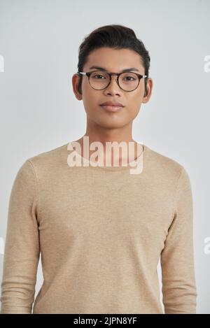 Porträt eines hübschen asiatischen Mannes mit stylischen Brillen, der vor weißem Hintergrund auf die Kamera blickt Stockfoto