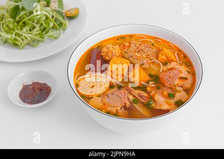 Bun Rieu Cua, Krabbenpaste Vermicelli-Suppe mit gehackten Garnelen, Tofu, Tomaten, Garnelenpaste, vietnamesisches Essen auf weißem Hintergrund isoliert, Nahaufnahme Stockfoto